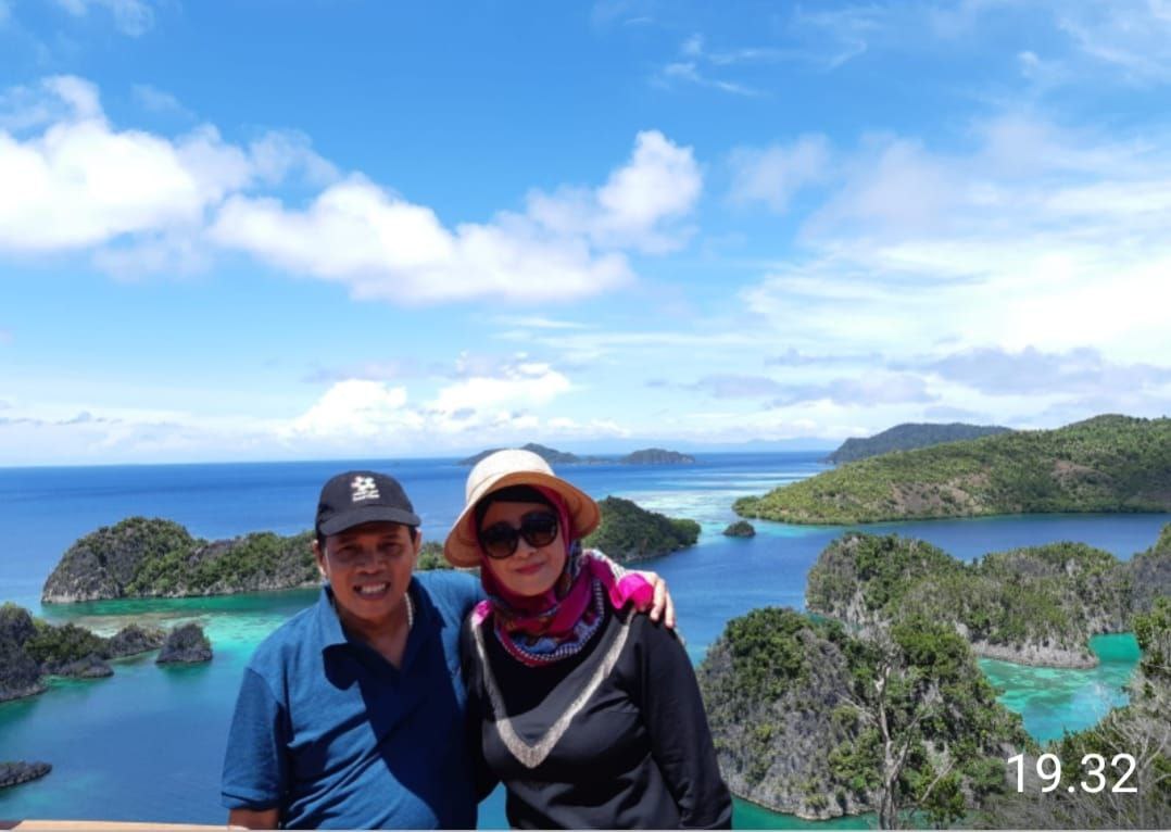 Tutin dan suami berlatar gugusan pulau Raja Ampat